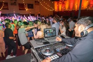 teens dance in school gymnasium with dj