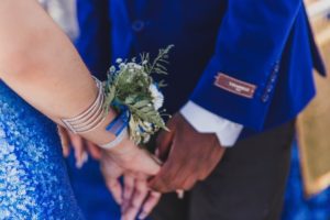 man and woman at formal standing holding hands