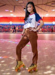 girl standing in roller skates inside a rink