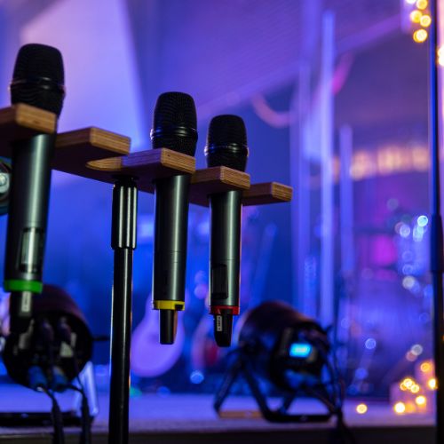 Wireless microphones on a stand with stage in background